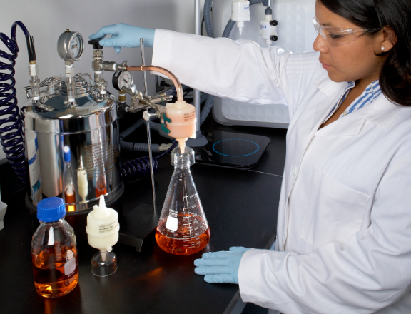 Scientist in lab performing sterile filtration of liquid