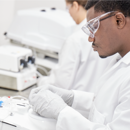 Scientist outfitted in PPE places tubing into the Sepax cell processing system