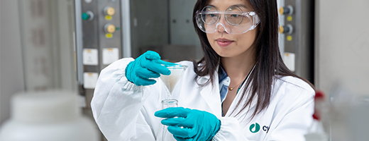 Scientist pouring liquid through filter paper into flask with filtration shown