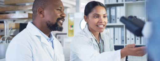 Two scientists smiling and pointing at a screen
