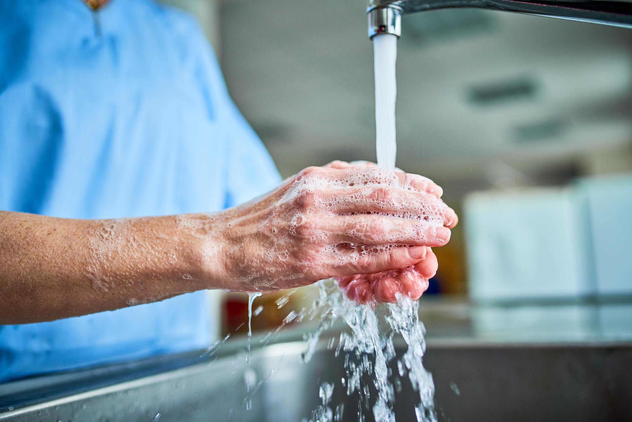 Clinician at hospital sink washing hands